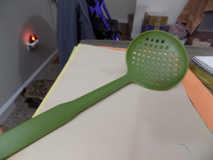 Green hard plastic strainer spoon circle holes in spoon bowl