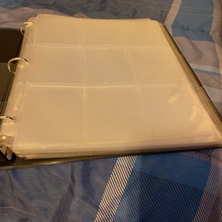 Small binder with (25) 9 pocket plastic pages (used)