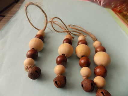 Set of 4  3 inch long wood beads and jingle bell ornaments on jute string