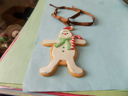 4 inch tall snowman/gingerbread man ornament in Santa hat green scarf on brown ribbon hanger