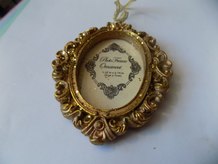 Gold resin glittery oval photo ornament frame on gold metallic ribbon