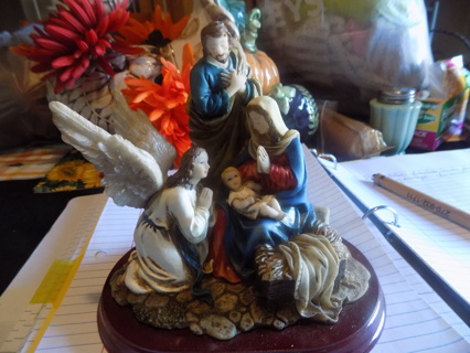 Resin statue of the Holy family being vistied by an angel on oval cherrywood base