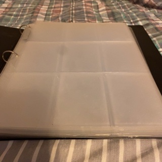 Small binder with (25) 9 pocket plastic pages (used)