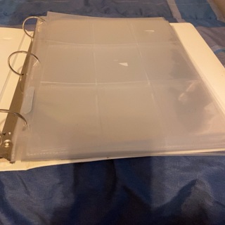 Small binder with (25) 9 pocket plastic pages (used)