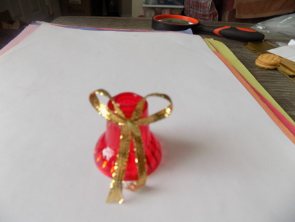 Vintage red plastic bell ornament trimmed in gold bow