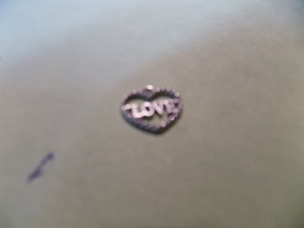 Silvertone twisted heart charm says LOVE in middle