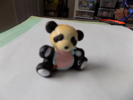 2 inch tall resin Panda bear wearing pink bib trimmed in blue