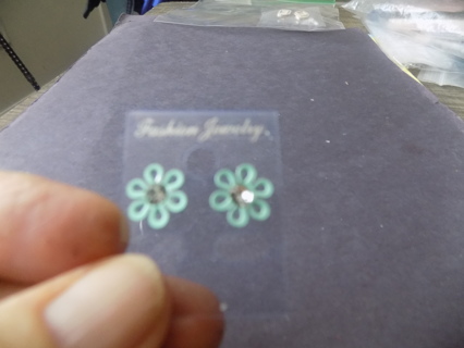 Pair of mint green hollow petal daisy post earrings with rhinestone center