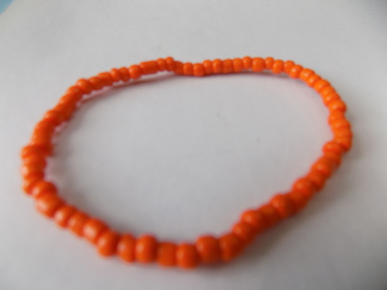 Orange E bead bracelet on stretchy cord