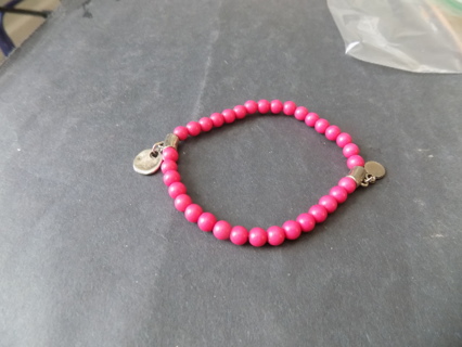 Bracelet hot pink wood beads with 2 silvertone charms on stretchy cord