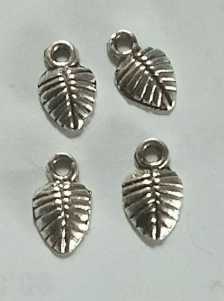 4 tiny silver tone leaf charm. Use the get it now option and get a free surprise
