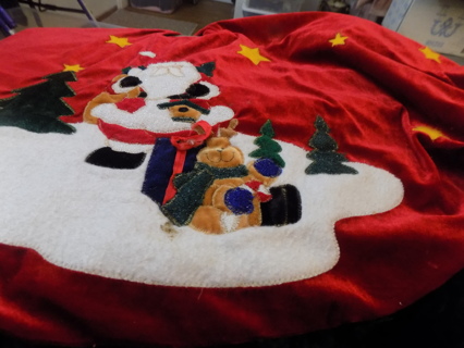 Red velvet tree skirt has Santa holding bird house, stuff reindeer presents trees, stars