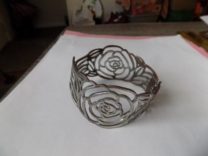 Silvertone bangle bracelet with large hollow roses cut out