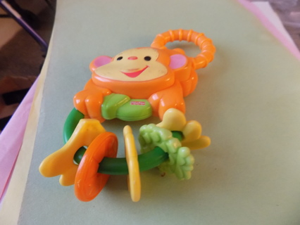 Orange plastic monkey baby rattle and 5 fruit rings attached