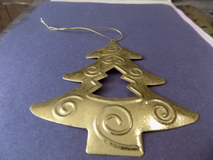 5 inch goldtone tree shape ornament with cut out tree in center, textured swirls