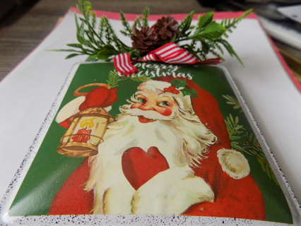 4 inch square metal Santa ornament with pine ocnes and greenery at top