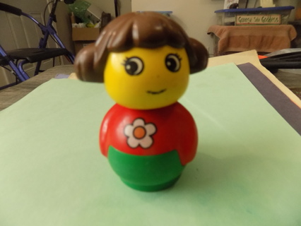 3 inch tall Duplo girl wearing red shirt with daisy on it, brown hair