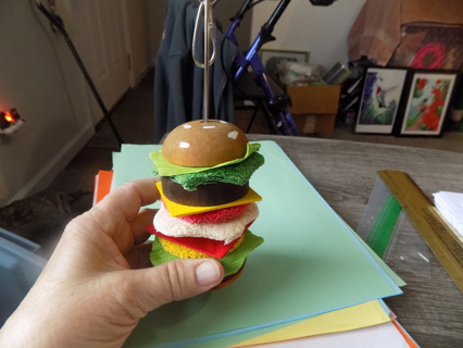 Hanging bird toy looks like a stacked hamburger 8 inch tall with adjustable clip