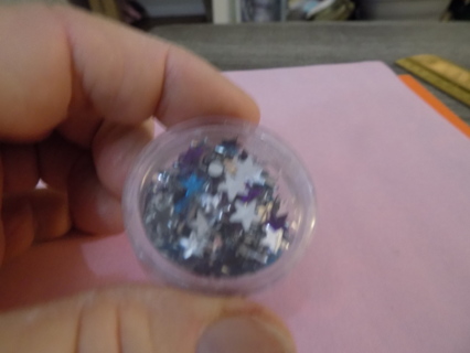 Round acrylic contaner filled with glittery stars for crafts