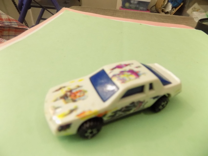Hot Wheels white car with paint pattern all over it blue tinted windows