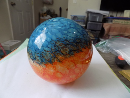 4 inch round heavy thick hand blown glass ornament orange & blue flat bottom sits on shelf