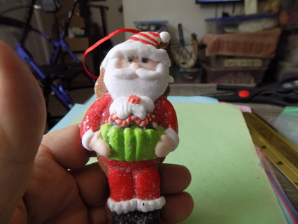 5 inch tall polylmar clay Santa holding big cupcake in green paper liner