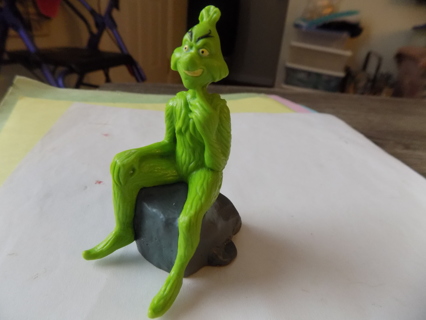 3 inch Grinch sitting on a rock pvc toy