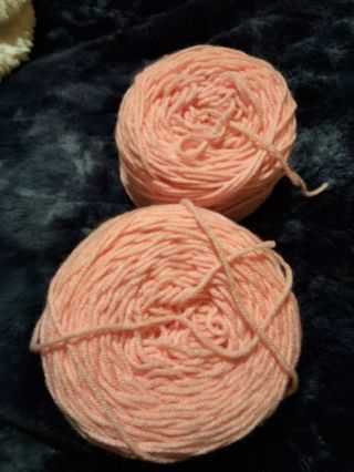 3 pink skeins of yarn one green and one burgundy