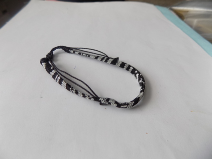 Bracelet adjustable woven mostly black trim in white