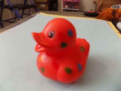 Red rubber duckie polkadots in blue green red, and yellow