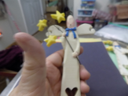 Wooden angel tall skinny heart cut out of her gown holds pole with 3 stars