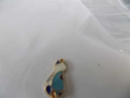blue and white enameled cat charm sitting up back towards you tail moves