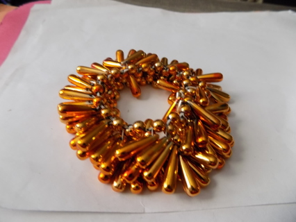 gold and orange elongated tear drop shaped beaded bracelet on stretchy cord