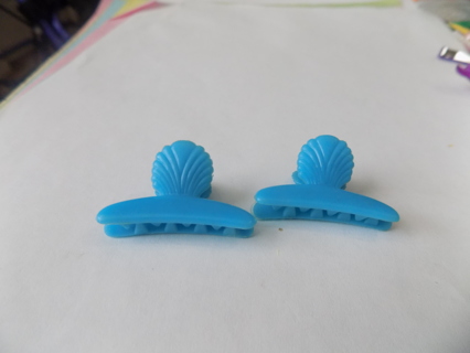 pair of light blue hair clips with sea shell on top