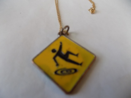 Necklace yellow enameled has man climbing and swirl under him