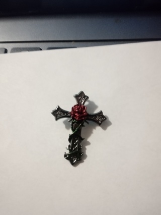 Silver cross with rose in center over stainless steel 