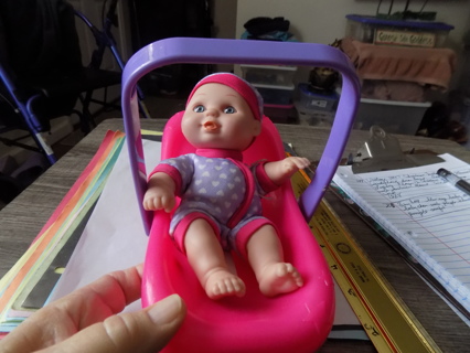 8 inch tall blue eye baby doll in pink baby chair with a purple handle