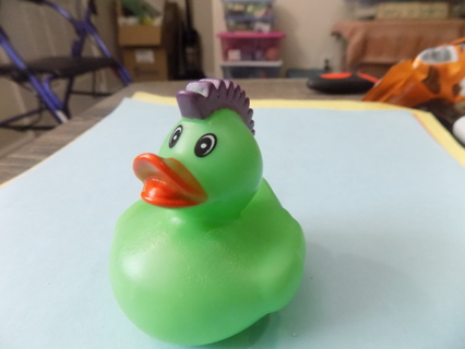 Green rubber duckie with a purple mohawk hairdo