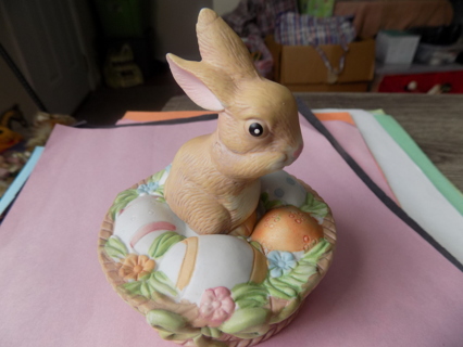 5 inch tall little tan bunny in ceramic basket of colored eggs and flowers