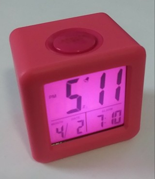 Hot pink battery powered alarm clock with month/day setting.