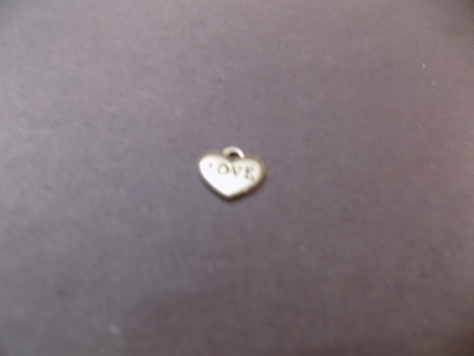 Silvertone solid heart charm says LOVE