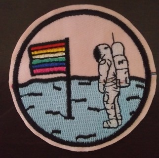 Iron on patch. Rainbow flag on planet with astronaut.