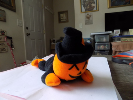 pumpkin scarecrow plush black and orange crawling pose, in witches hat