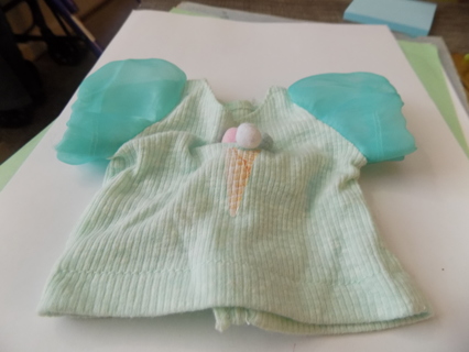 Mint green baby doll blouse has 3 pom poms on front