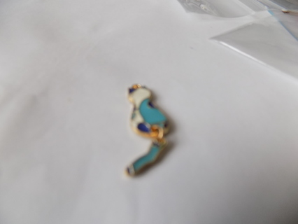 blue and white enamel cat charm sits up back facing you tail moves