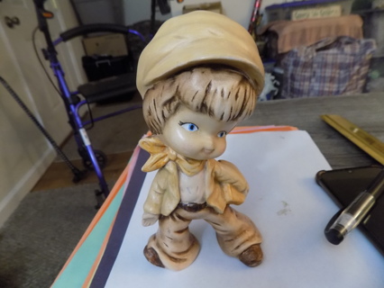 7 inch handmade ceramic boy dressed in yellow and light brown carries a book , light tan hair