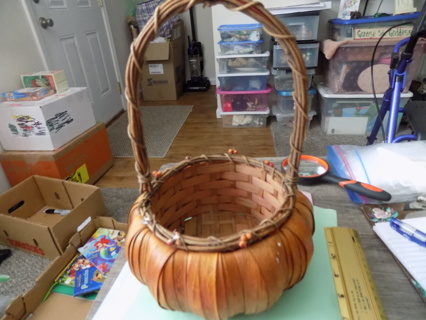 8 inch round pumpkin shaped woven basket with long handle trim in orange berries on rim