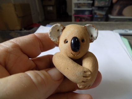 2 inch tall stoneware Koala bear hangs onto the edge of a flower pot