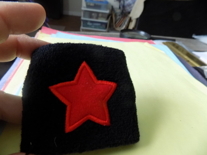 Black knit sports wrist band cuff with red 3D star applique