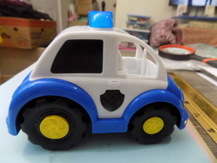 5 1/2 inch long and 4 tall plastic blue & white police car push car